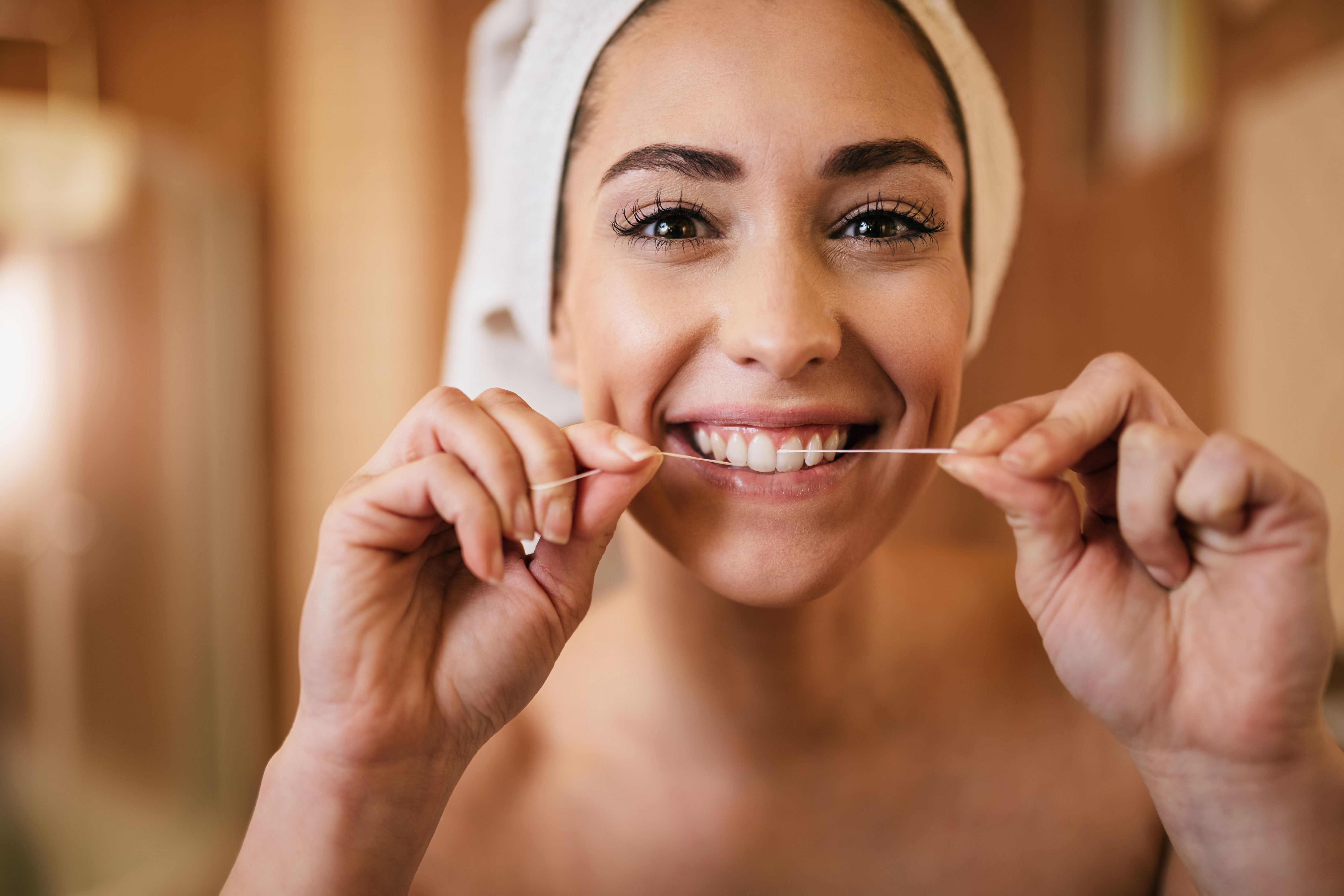 beautiful-woman-using-dental-floss-cleaning-her-teeth-bathroom