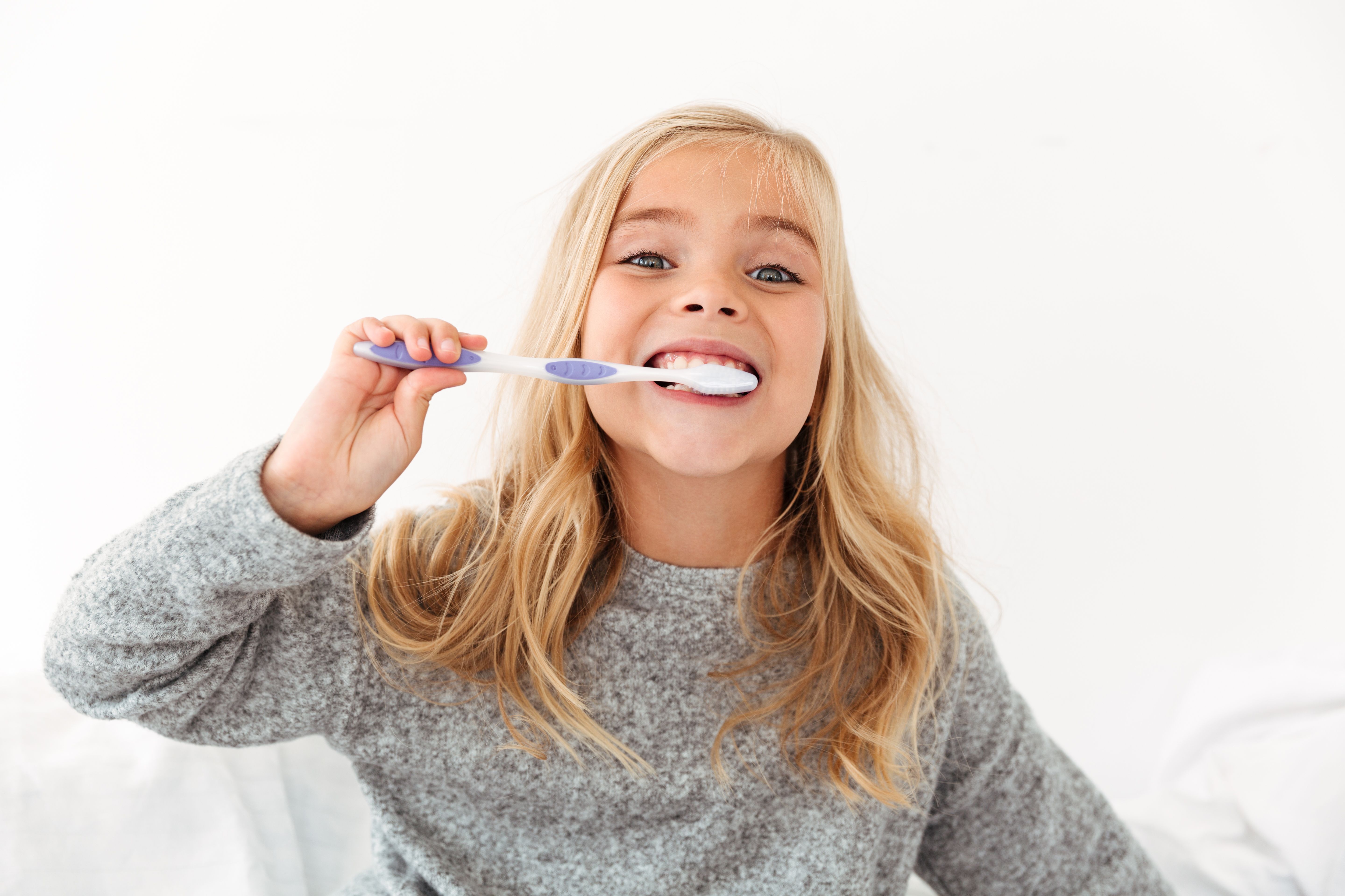 close-up-portrait-cute-kid-gray-pajamas-brushing-her-teeth