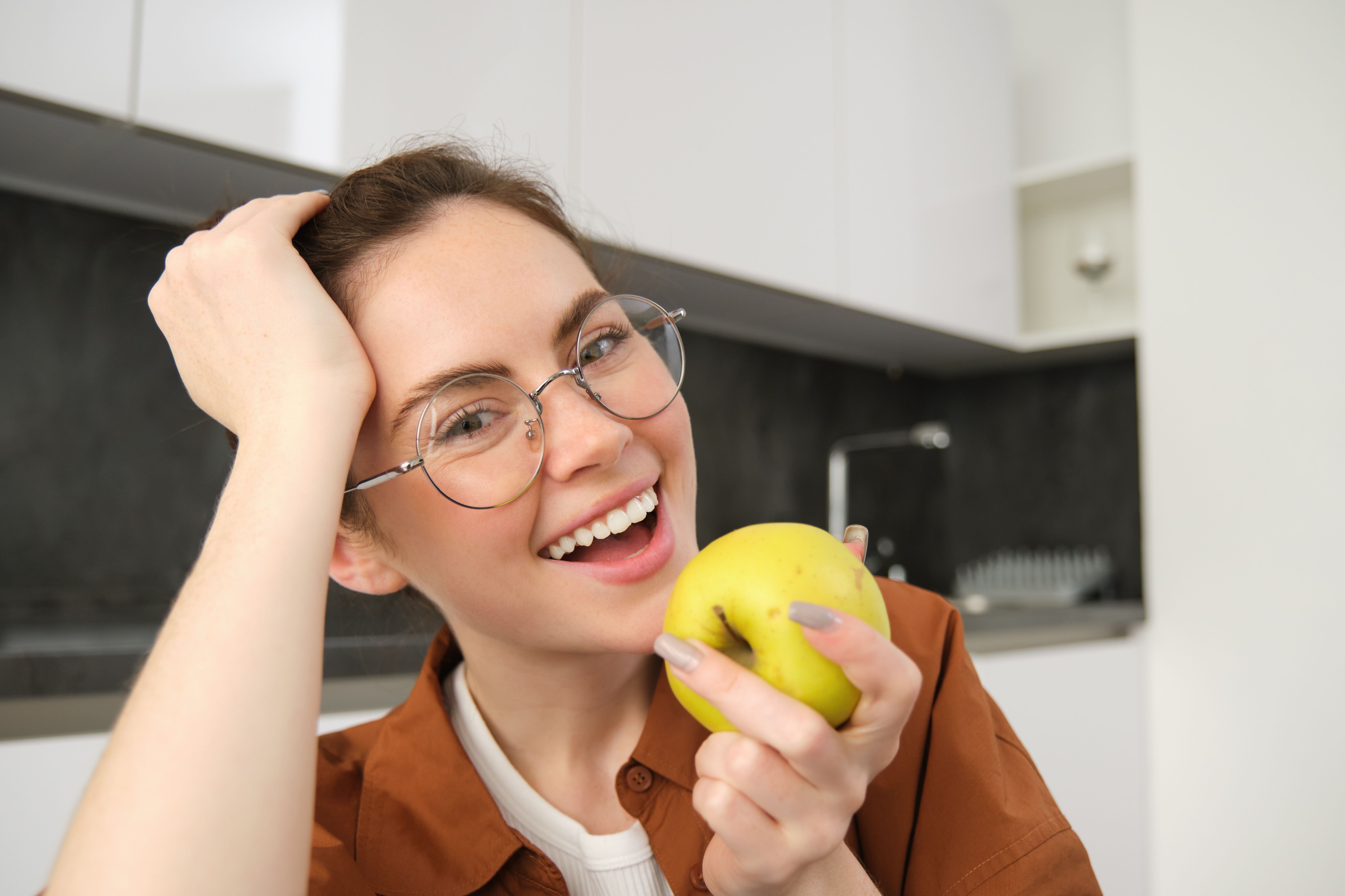 close-up-portrait-happy-stylish-young-woman-home-biting-apple-eating-fruits-home