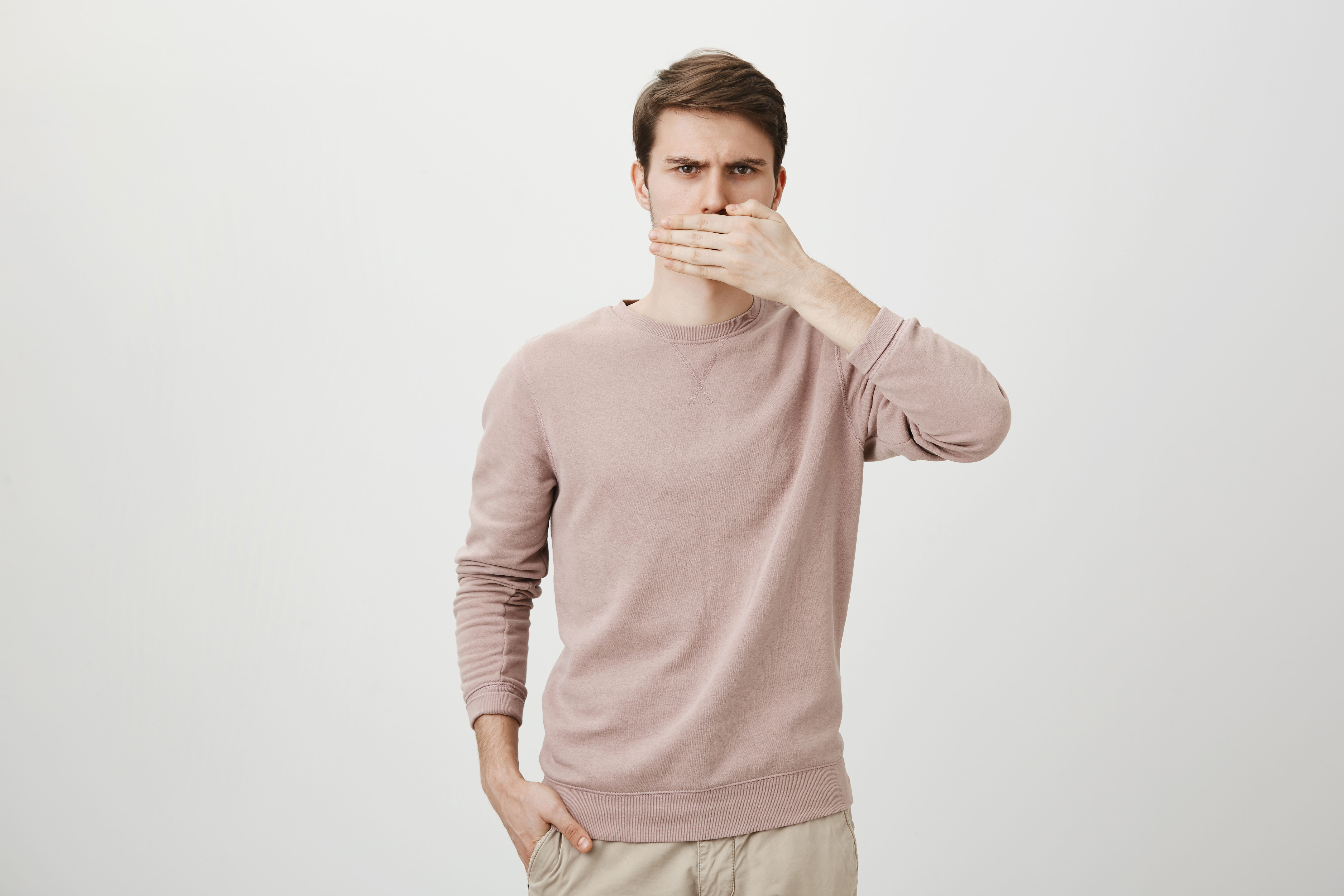 displeased-angry-man-shut-mouth-with-palm