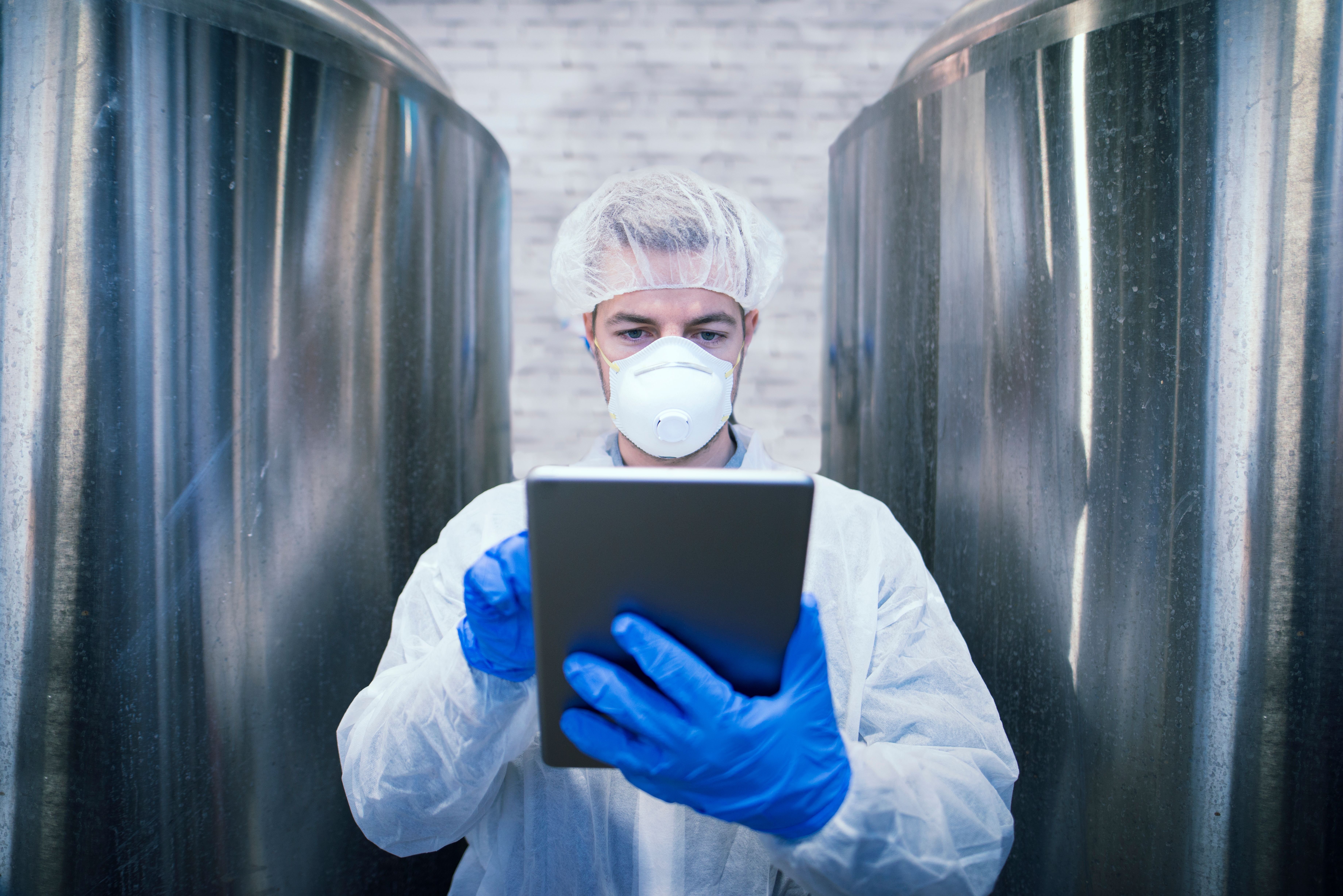 portrait-technologist-white-protective-uniform-holding-tablet-food-production-factory