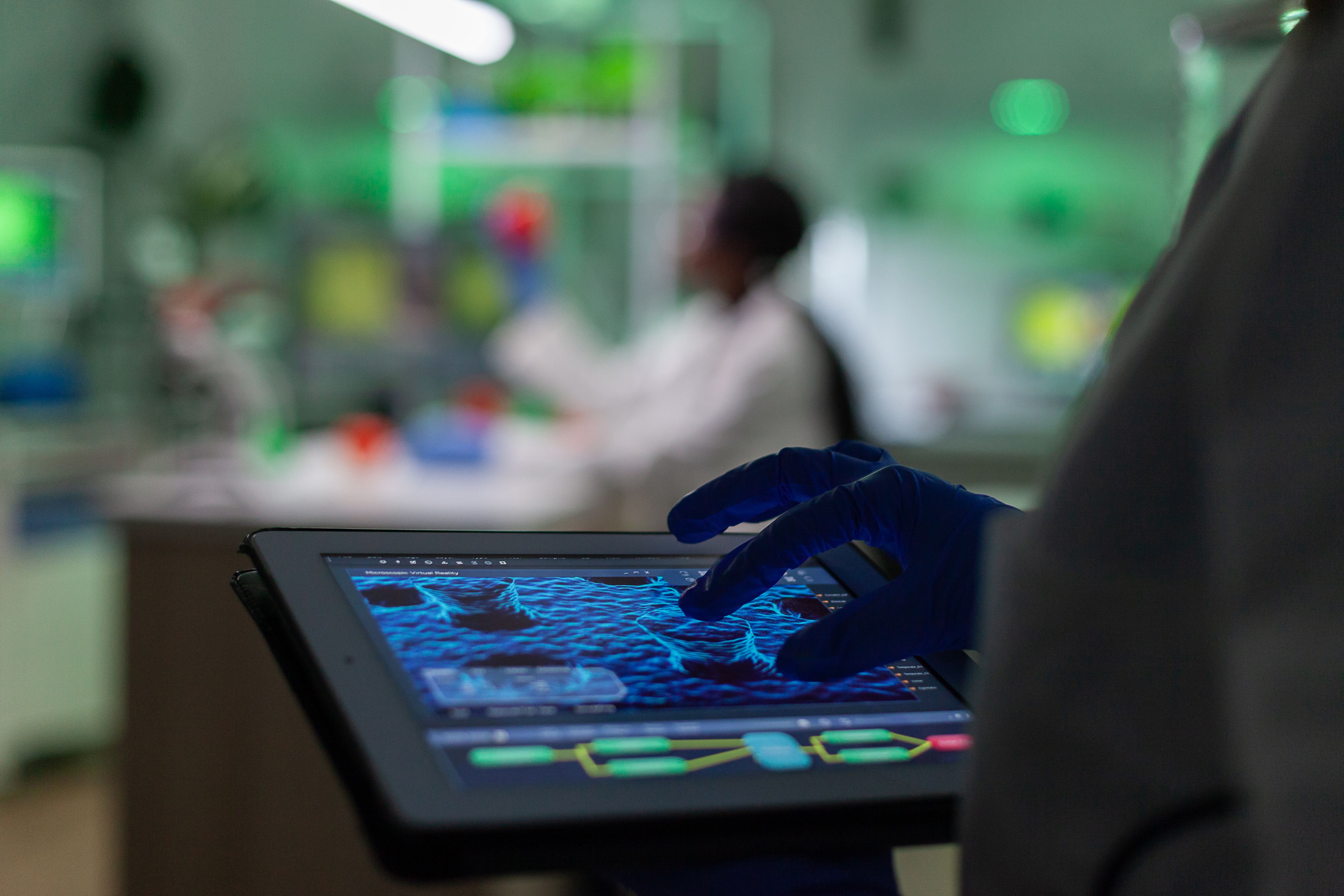 scientist-researcher-doctor-analyzing-genetic-mutation-test-using-tablet-while-her-collegue-typing-biological-expertise-computer